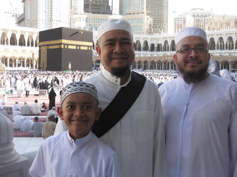 three bald men in front of kaabah